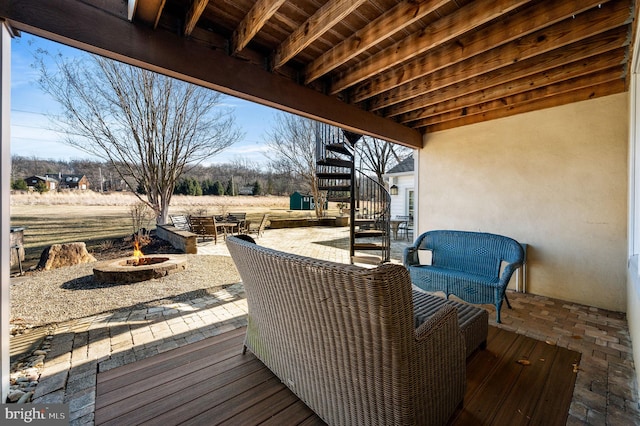 wooden terrace with a fire pit, a patio, and stairway