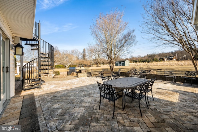 view of patio with stairs and outdoor dining space