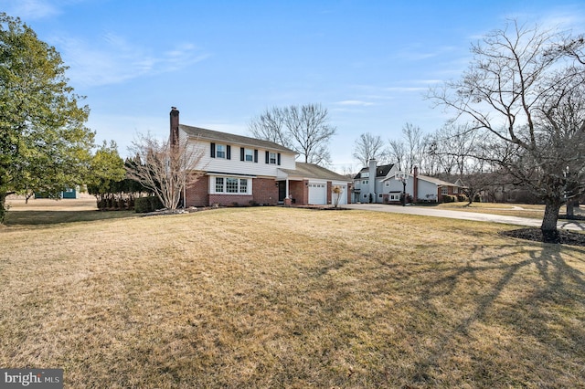 view of front of property featuring a front yard, brick siding, a chimney, and an attached garage