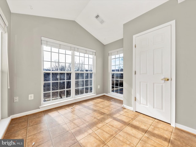 unfurnished room featuring vaulted ceiling and light tile patterned flooring