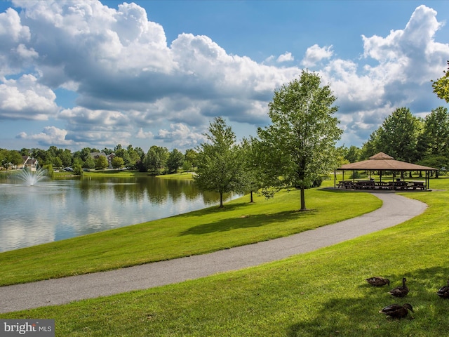 view of property's community featuring a gazebo, a water view, and a lawn