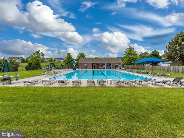 view of pool with a yard, an outbuilding, and a patio area