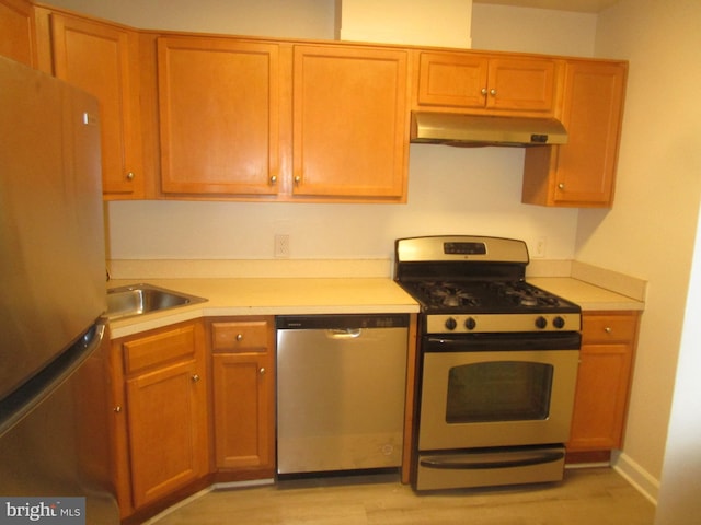 kitchen with stainless steel appliances, light hardwood / wood-style floors, and sink