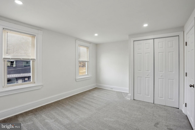 unfurnished bedroom featuring a closet and light carpet