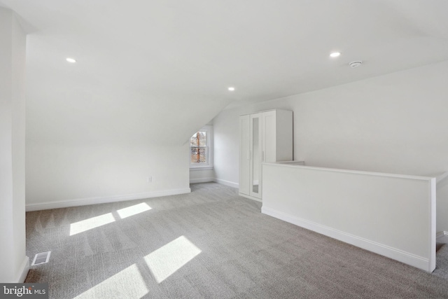 bonus room featuring light colored carpet and vaulted ceiling