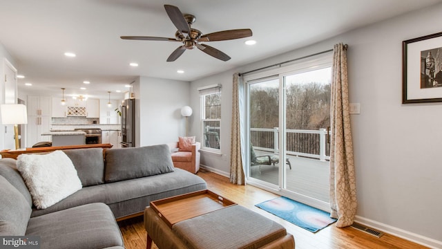 living room featuring ceiling fan and light hardwood / wood-style floors