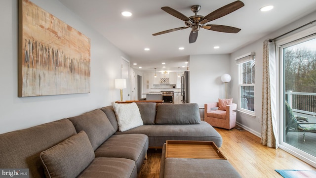 living room featuring ceiling fan and light wood-type flooring