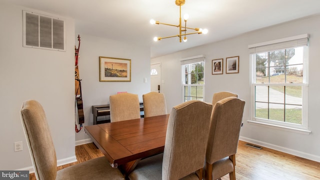 dining room featuring a wealth of natural light, light hardwood / wood-style flooring, and a chandelier