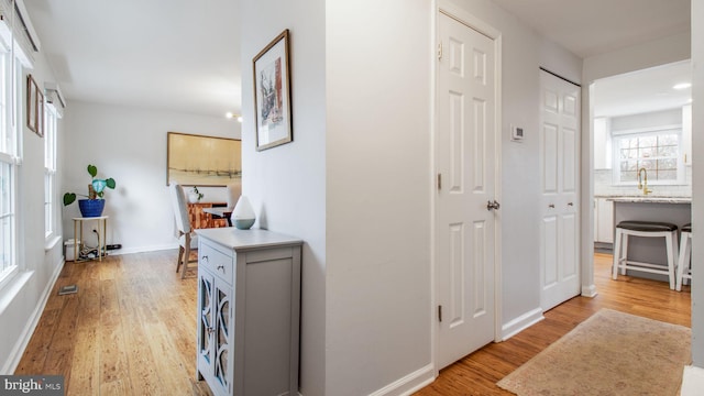 hallway featuring sink and light wood-type flooring