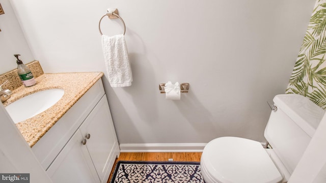 bathroom featuring hardwood / wood-style flooring, vanity, and toilet