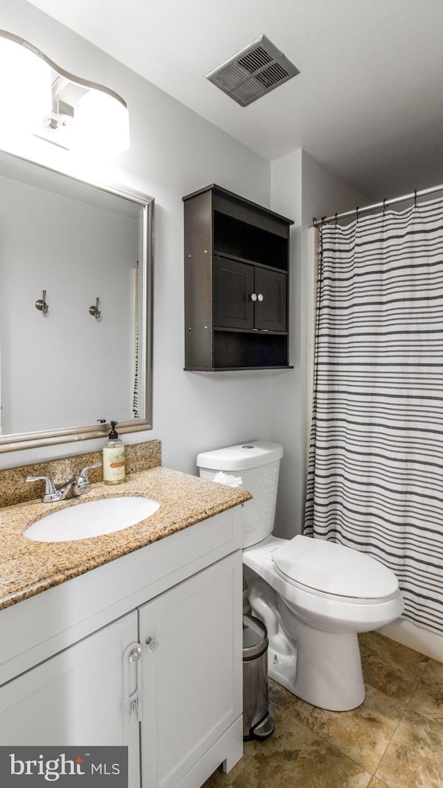 bathroom with vanity, a shower with shower curtain, and toilet