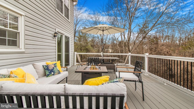 deck featuring an outdoor living space with a fire pit