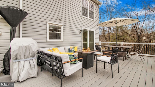 deck with an outdoor living space with a fire pit