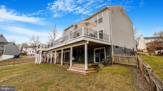 rear view of house featuring a wooden deck and a yard