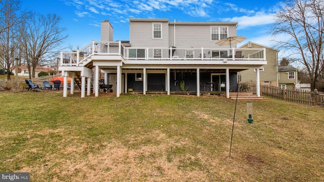 back of house with a wooden deck and a yard