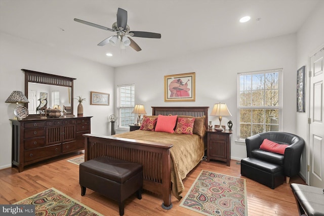 bedroom with multiple windows, ceiling fan, and light wood-type flooring