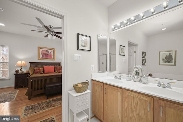 bathroom featuring hardwood / wood-style flooring, vanity, a tub, and ceiling fan