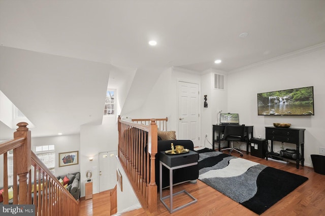 living room with wood-type flooring and crown molding