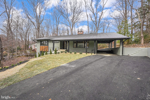 ranch-style house featuring a front yard and a carport