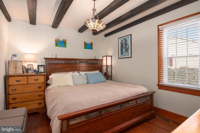 bedroom with beam ceiling, visible vents, baseboards, and wood finished floors