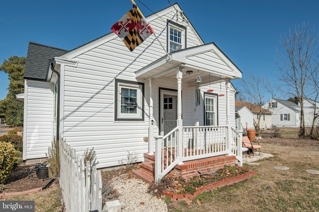 view of front of home featuring covered porch and a shingled roof