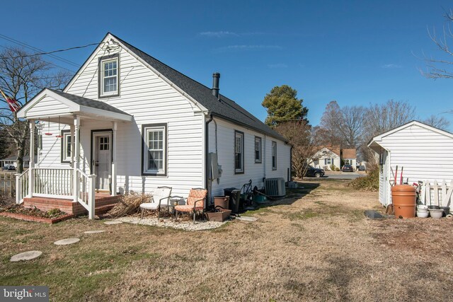 view of side of home featuring central AC, a lawn, and roof with shingles