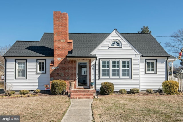 bungalow with a shingled roof, a chimney, and a front yard