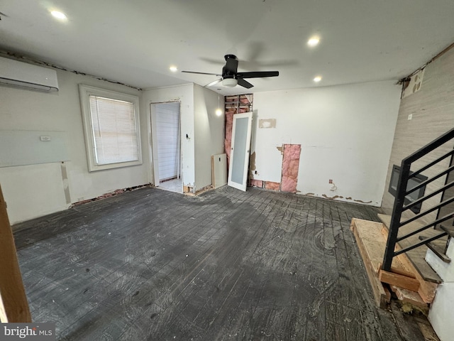 spare room featuring dark hardwood / wood-style floors, an AC wall unit, and ceiling fan