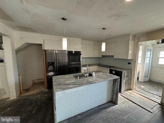 kitchen with sink, white cabinetry, light stone counters, black appliances, and decorative light fixtures