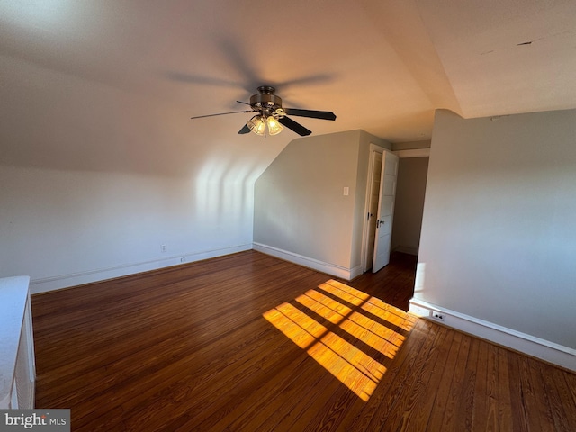 additional living space with vaulted ceiling, dark wood-type flooring, and ceiling fan