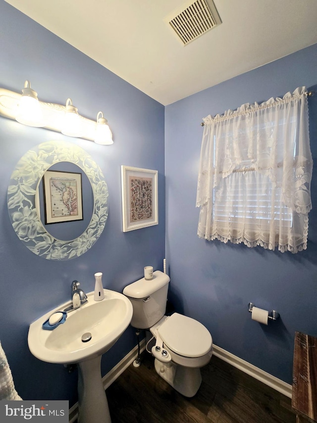 bathroom featuring hardwood / wood-style flooring, toilet, and sink