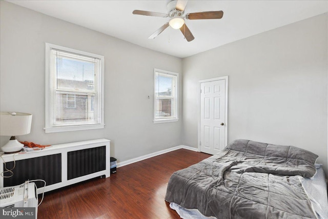 bedroom featuring dark wood-type flooring, ceiling fan, and radiator