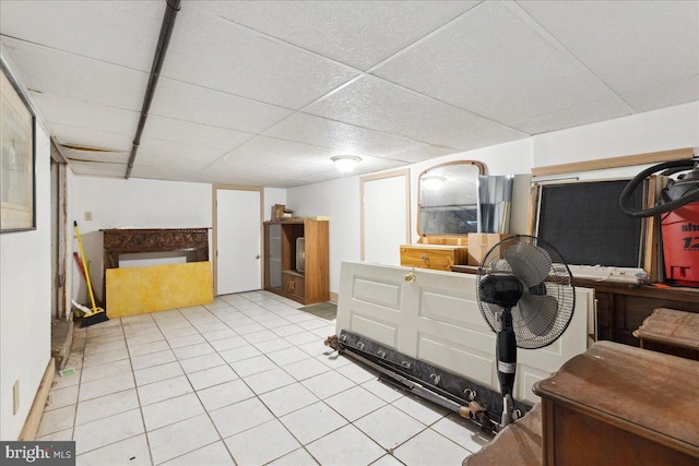 basement with light tile patterned flooring and a drop ceiling