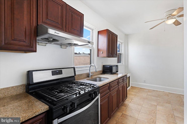 kitchen with range hood, sink, light stone countertops, and stainless steel gas range oven