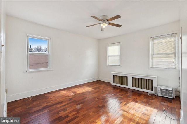 empty room with ceiling fan, dark hardwood / wood-style floors, and radiator