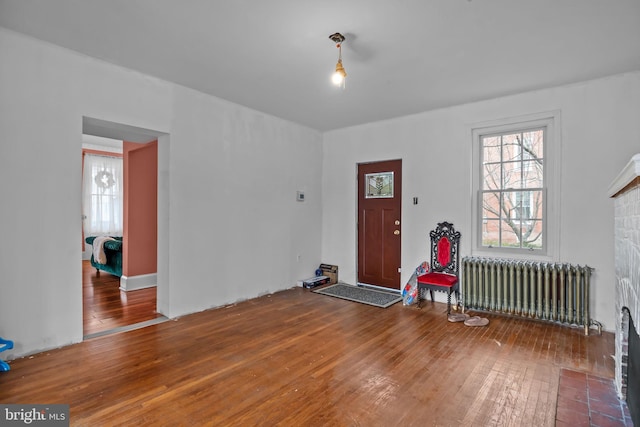 foyer entrance featuring a healthy amount of sunlight, wood-type flooring, and radiator