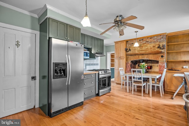 kitchen featuring hanging light fixtures, ornamental molding, green cabinetry, stainless steel appliances, and light wood-type flooring