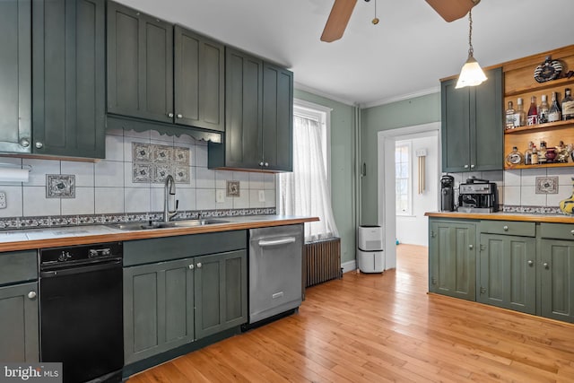 kitchen featuring radiator, dishwasher, sink, hanging light fixtures, and light wood-type flooring