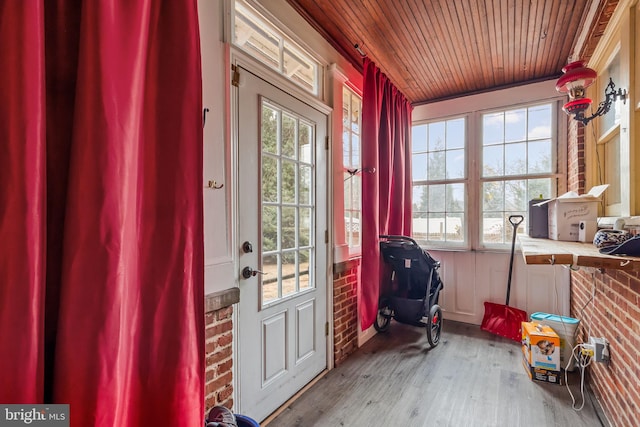 entryway with brick wall, a healthy amount of sunlight, wood ceiling, and light hardwood / wood-style floors