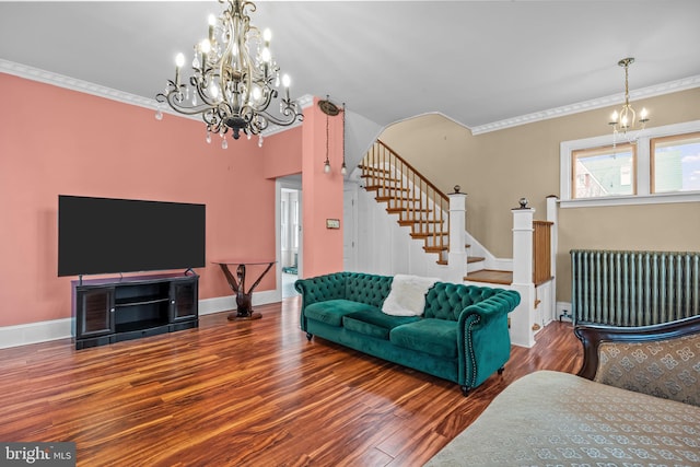 living room featuring hardwood / wood-style flooring, crown molding, radiator heating unit, and a notable chandelier