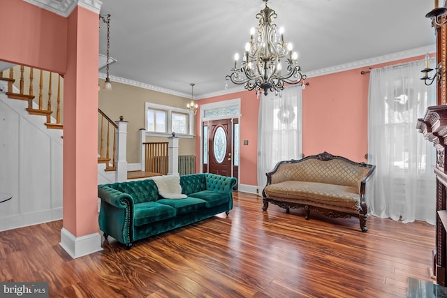 living room with hardwood / wood-style floors, a notable chandelier, and ornamental molding