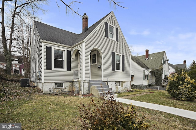 view of front of property with cooling unit and a front lawn