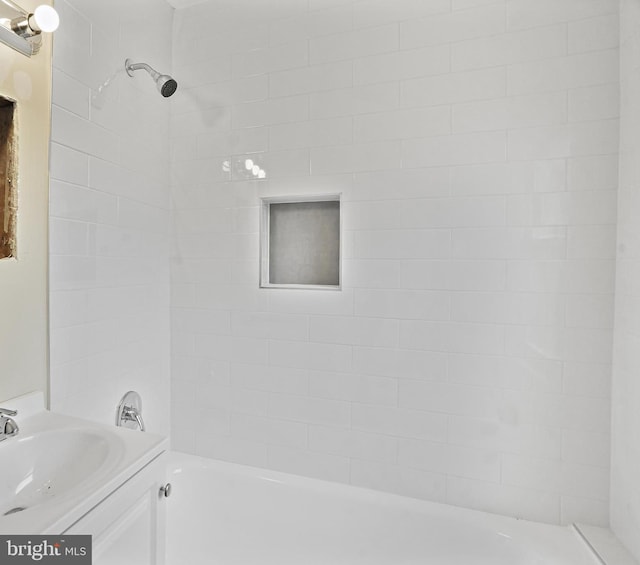 bathroom featuring tiled shower / bath and vanity