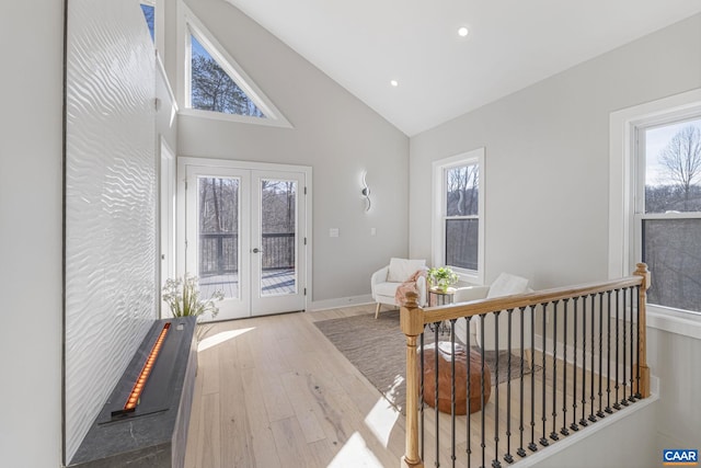 interior space featuring hardwood / wood-style floors, a wealth of natural light, high vaulted ceiling, and french doors