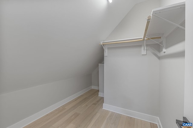 spacious closet featuring lofted ceiling and light hardwood / wood-style flooring