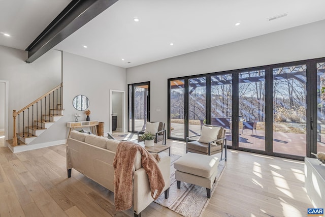 living room featuring beam ceiling and light hardwood / wood-style floors