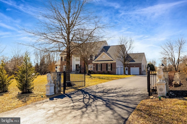 view of front of house featuring a fenced front yard, a gate, brick siding, and a garage