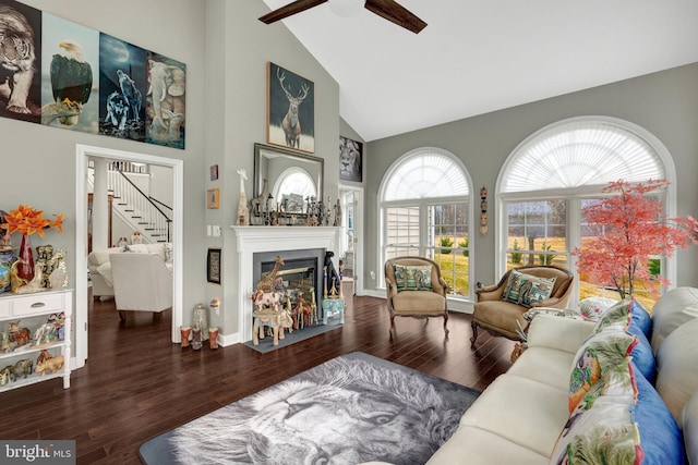 living room with stairs, a fireplace, high vaulted ceiling, and wood finished floors