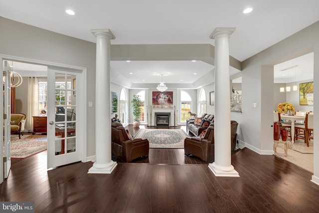 living room with recessed lighting, a fireplace, baseboards, hardwood / wood-style floors, and ornate columns