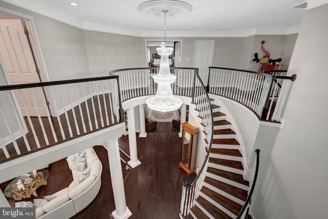 stairway with wood finished floors, crown molding, and an inviting chandelier